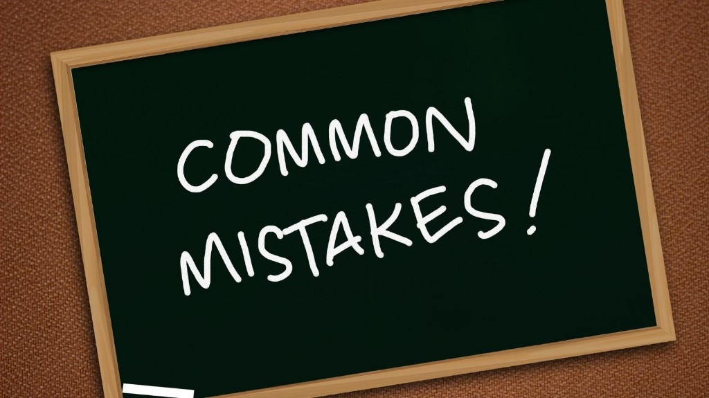 Pizarra con marco de madera y texto que dice COMMON MISTAKES en letras grandes.